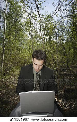Stock Photo - Working on a pc in a woodland glade. Fotosearch