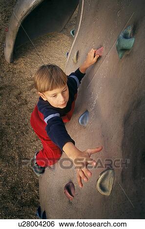 Young boy ascending climbing wall View Large Photo Image Stock Photograph - Young boy ascending climbing wall. Fotosearch