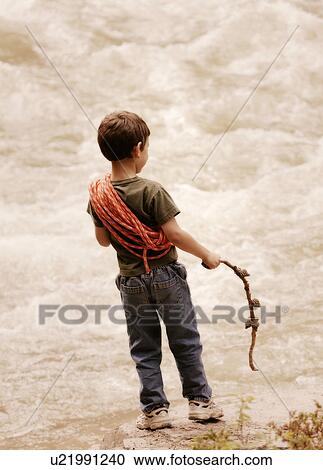 Stock Image - Young boy at edge of torrent. Fotosearch