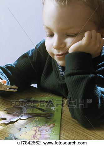 Young boy doing a puzzle View Large Photo Image Stock Image - Young boy doing a puzzle. Fotosearch