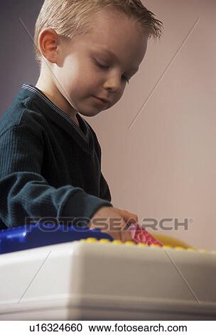 Stock Image - Young boy playing with large Lego blocks. Fotosearch