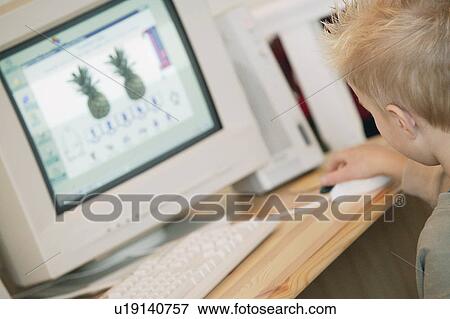 Young boy working at computer View Large Photo Image Stock Photo - Young boy working at computer. Fotosearch