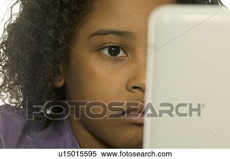 Young girl using a computer View Large Photo Image Stock Photography - Young girl using a computer. Fotosearch