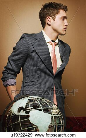 Stock Photo - Young man with globe. Fotosearch
