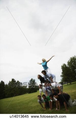 Stock Photography - A group of young people making a pyramid. Fotosearch