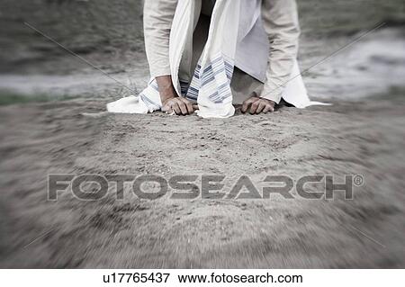 Stock Photo - A man kneeling. Fotosearch