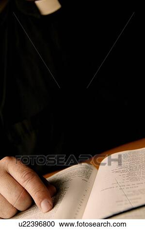 Stock Image - A minister reads the Bible. Fotosearch