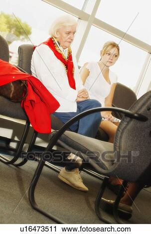 Stock Image - A senior woman and a teenage girl waiting together. Fotosearch