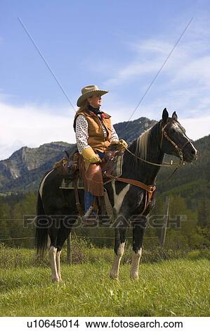 A woman on a horse against mountains View Large Photo Image Picture - A woman on a horse against mountains. Fotosearch