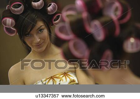Stock Photo - A woman watching in the mirror. Fotosearch