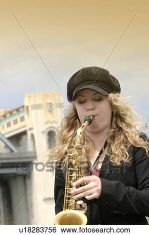 A young woman playing the saxophone View Large Photo Image Stock Photograph - A young woman playing the saxophone. Fotosearch