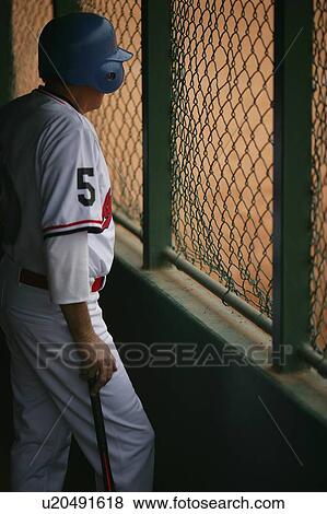Stock Photo - Baseball player in dugout. Fotosearch