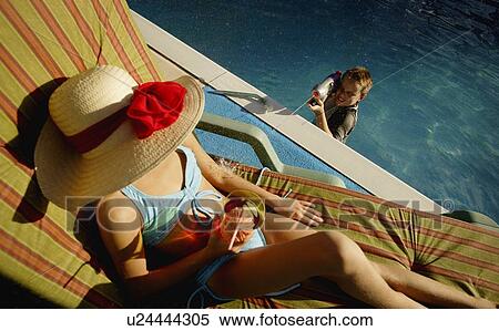 Boy spraying woman sunbathing View Large Photo Image Stock Photography - Boy spraying woman sunbathing. Fotosearch