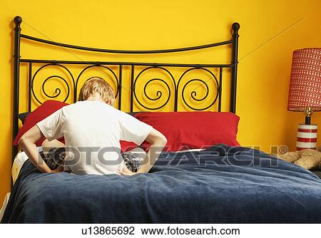 Stock Image - Child sulks on bed. Fotosearch
