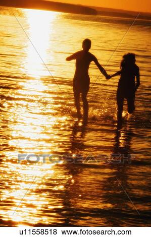 Couple hand in hand in water View Large Photo Image Stock Photo - Couple hand in hand in water. Fotosearch