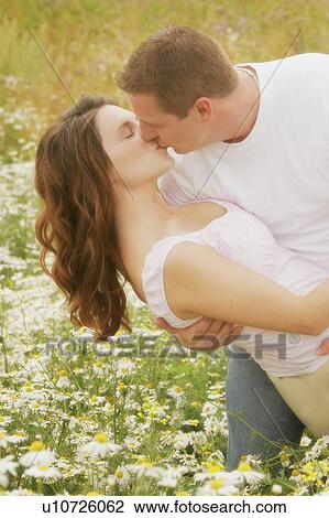 Couple kiss in a field of daisies View Large Photo Image Stock Image - Couple kiss in a field of daisies. Fotosearch
