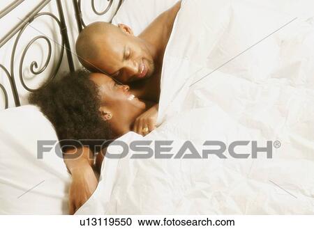 Couple relaxing in bed View Large Photo Image Stock Image - Couple relaxing in bed. Fotosearch