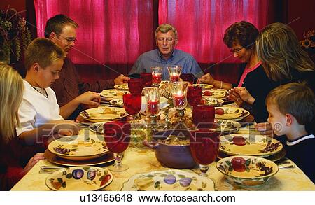 Stock Photo - Family praying over Thanksgiving meal. Fotosearch