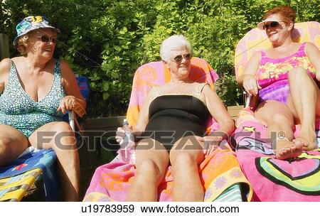 Group of three women sunbathing View Large Photo Image Stock Photo - Group of three women sunbathing. Fotosearch