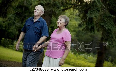 Happy senior couple strolling in the park View Large Photo Image Stock Image - Happy senior couple strolling in the park. Fotosearch