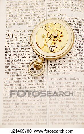 Stock Image - Inside of pocket watch on the Bible. Fotosearch
