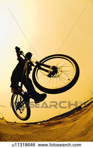 Silhouette of a cyclist against a yellow sky View Large Photo Image Stock Photograph - Silhouette of a cyclist against a yellow sky. Fotosearch