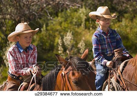 Stock Photo - Two boys on horses. Fotosearch