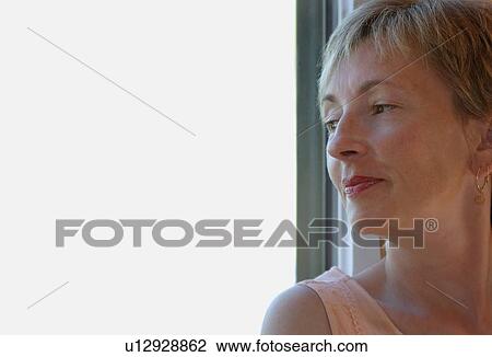 Stock Image - Woman looking out window. Fotosearch
