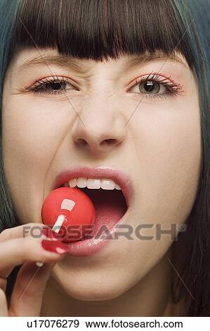 Woman trying to bite sucker View Large Photo Image Stock Photo - Woman trying to bite sucker. Fotosearch