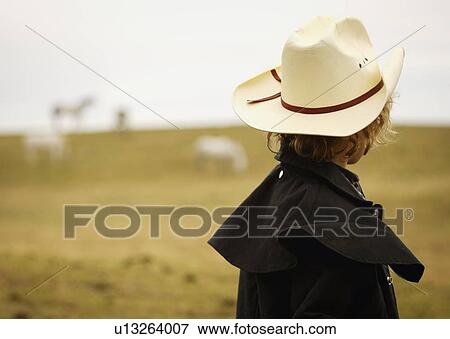 Young cowboy in field View Large Photo Image Stock Photo - Young cowboy in field. Fotosearch