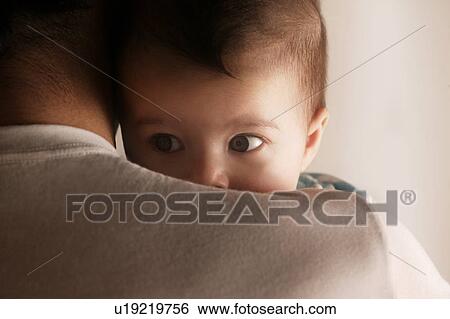 Baby peering over dads shoulder View Large Photo Image Stock Photograph - Baby peering over dads shoulder. Fotosearch