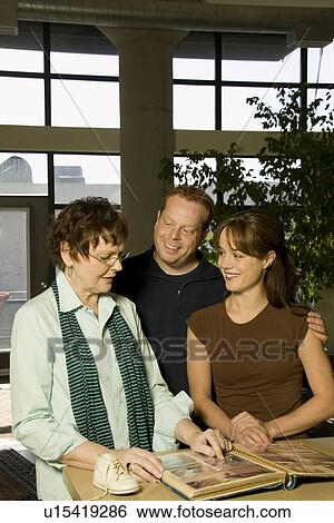 Stock Photograph - Family Looking through Photo Albums. Fotosearch