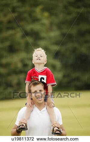 Father and son walking in rain View Large Photo Image Stock Image - Father and son walking in rain. Fotosearch