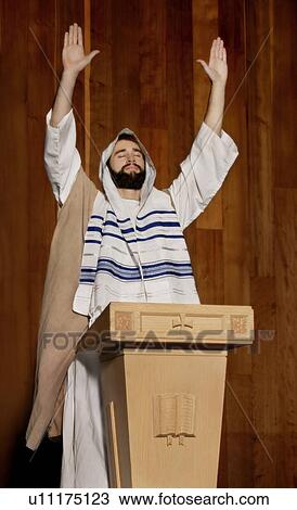 Stock Image - Man praying at a pulpit. Fotosearch