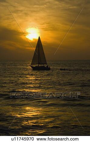 Stock Image - Sailboat at Sunset. Fotosearch