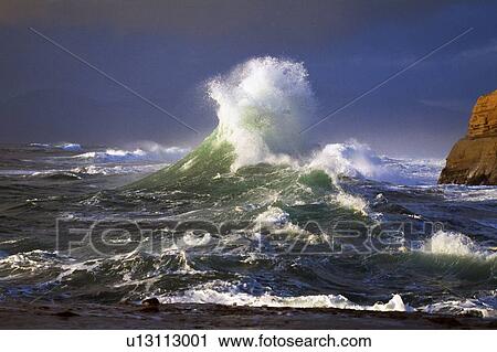 Stock Image - Wave crashing, distant storm, Cape Kiwanda. Fotosearch