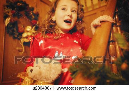Stock Image - Child comes down the stairs on Christmas morning. Fotosearch