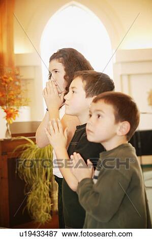 Stock Photo - Children praying. Fotosearch