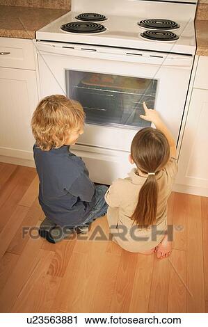 Stock Image - Children watching the oven. Fotosearch