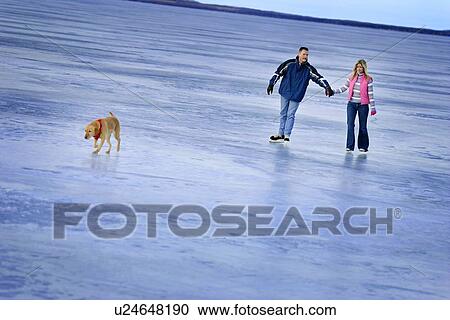 Couple skating on a frozen lake View Large Photo Image Stock Image - Couple skating on a frozen lake. Fotosearch