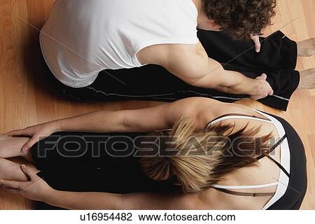 Stock Image - Couple stretching together. Fotosearch
