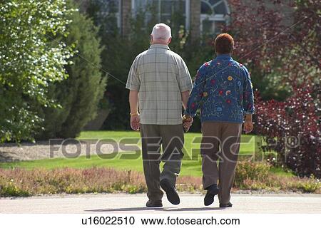 Couple walking hand in hand View Large Photo Image Stock Image - Couple walking hand in hand. Fotosearch