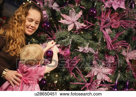 Stock Image - Decorating Christmas tree. Fotosearch