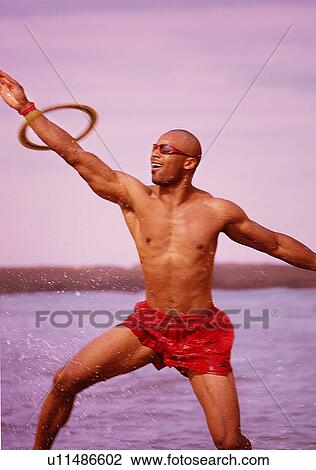 Stock Image - Man catching flying disc. Fotosearch