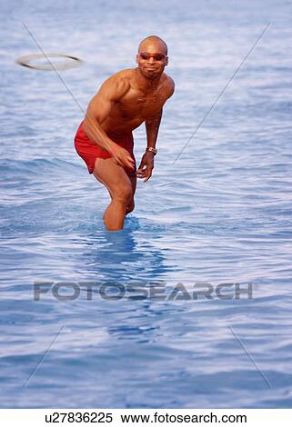 Man playing Frisbee in water View Large Photo Image Stock Photography - Man playing Frisbee in water. Fotosearch