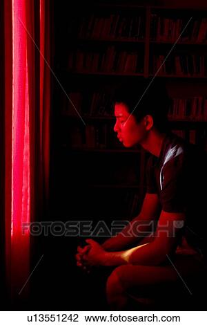 Stock Image - Man prays in hidden room. Fotosearch