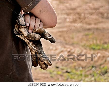Stock Image - Man with worn gloves in hand. Fotosearch