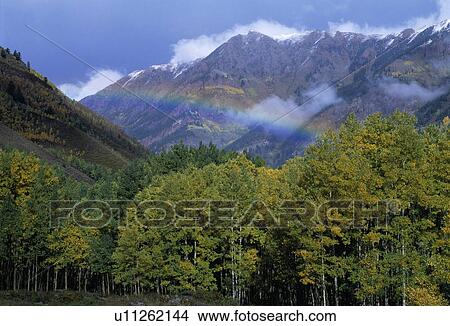 Rainbow and clearing storm in a valley between mountain peaks View Large Photo Image Picture - Rainbow and clearing storm in a valley between mountain peaks. Fotosearch