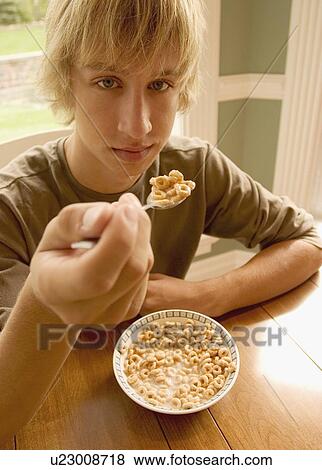 Teenager eating cereal View Large Photo Image Stock Photo - Teenager eating cereal. Fotosearch