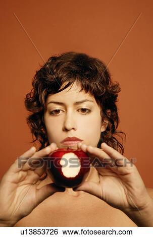 Stock Photograph - Woman holding bitten apple. Fotosearch